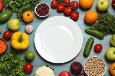 Farklı vejetaryen ürünler ve açık mavi ahşap masa, üst manzara.