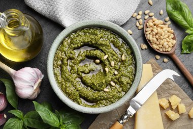 Lezzetli pesto sosu kasede, fesleğende, çam fıstığında, peynirde, sarımsakta ve yağda siyah masada.