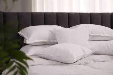 Bir sürü yumuşak beyaz yastık ve yorgan var.