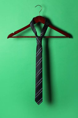 Yeşil arka planda siyah çizgili kravat askısı