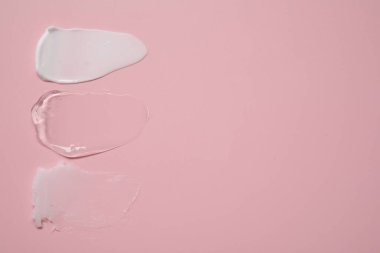 Pembe arka planda yüz kremi ve jöle, üst manzara. Metin için boşluk