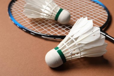 Feather badminton mekik horozu ve raket kahverengi arka planda, yakın plan
