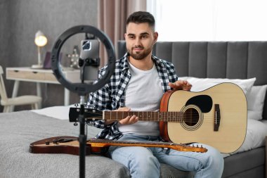 Müzik blogcusu evde akıllı telefon ve halka lambasıyla gitar dersi kaydediyor