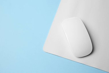 Açık mavi arka planda fareli bir kablosuz fare, üst manzara. Metin için boşluk