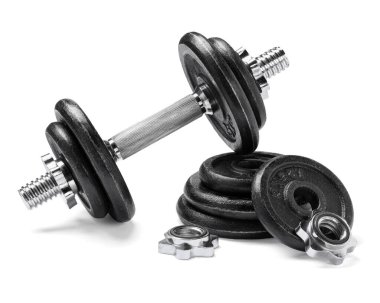 Metal dambıl ve beyaz arka planda parçalar. Spor malzemeleri.