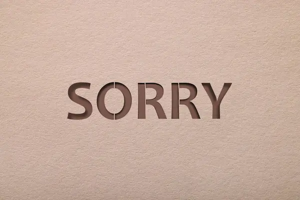 Stock image Word Sorry on beige background, apology card design