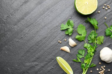 Taze kişniş yaprakları, kurutulmuş tohumlar, sarımsak ve limon siyah desenli masa, düz yatak. Metin için boşluk