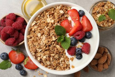 Böğürtlenli tahıl gevreği ve gri desenli masada yoğurt.