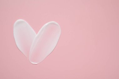 Pembe arka planda yüz kremi, üst manzara. Metin için boşluk