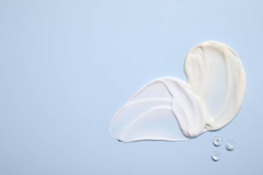 Açık mavi arka planda yüz kremi ve jöle, üst manzara. Metin için boşluk