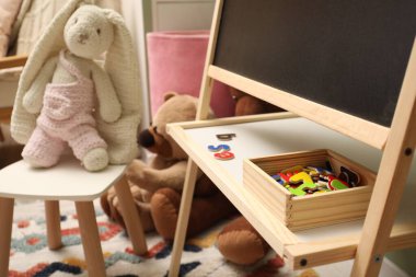 Çocuk odasında farklı oyuncaklar ve mobilyalar.