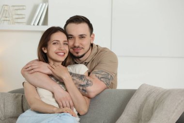 Adam evde mutlu kız arkadaşına sarılıyor.