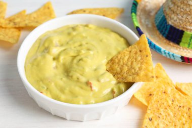 Beyaz ahşap masada cipsli guacamole, yakın plan.