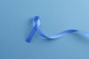 Renk arkaplanı üzerinde mavi farkındalık kurdelesi, üst görünüm