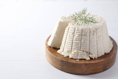 Beyaz ahşap masada dereotlu taze kesilmiş ricotta (krem peynir). Metin için boşluk