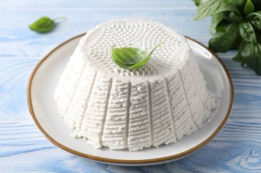 Açık mavi ahşap masada lezzetli ricotta (krem peynir)