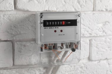 Beyaz tuğla duvarda elektrik sayacı. Enerji ölçüm aygıtı