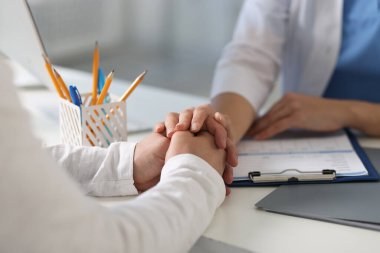 Hastanedeki beyaz masada hastayla çalışan profesyonel bir doktor.