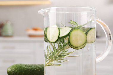 Salatalık suyunu biberiyeyle tazeleyen, arka planda biberiye ve sebze, yakın plan.