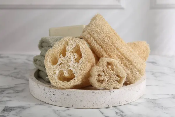 stock image Loofah sponges, towels and soap on white marble table