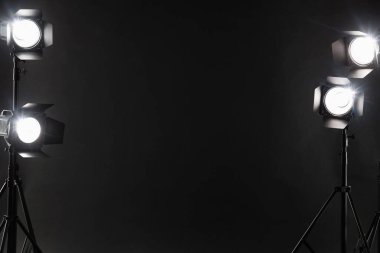 Stüdyoda karanlık fotoğraf arkaplanı ve profesyonel ışıklandırma ekipmanları