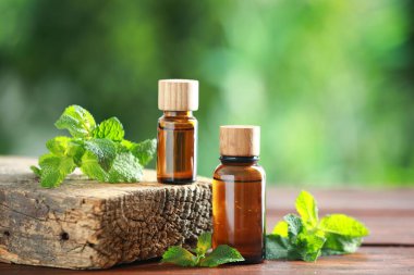 Naneli şeker şişeleri ve ahşap masa üzerinde taze yapraklar.