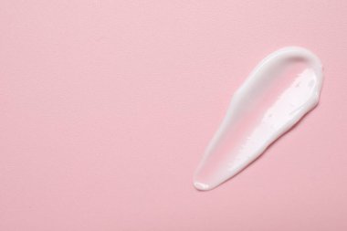 Pembe arka planda yüz kremi, üst manzara. Metin için boşluk