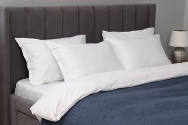 Evdeki yatakta bir sürü yumuşak yastık, yakın çekim.