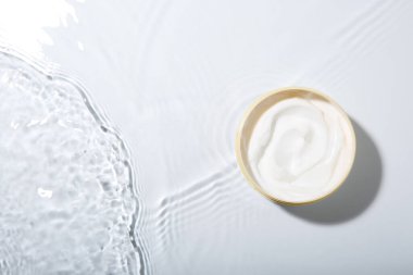 Kozmetik ürünü. Hafif arka planda kremalı kavanoz, üst manzara. Metin için boşluk