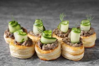 Delicious puff pastry with mushrooms, cucumber and dill on grey table clipart