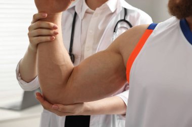 Spor sakatlığı. Hastanede hastayı muayene eden doktor, yakın plan.