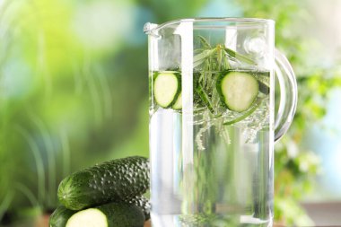 Biberiyeli salatalık suyu ve biberiye, bulanık yeşil arka planda, yakın planda