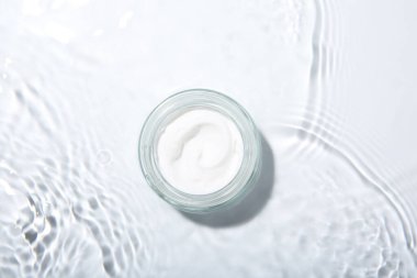 Kozmetik ürünü. Hafif arka planda kremalı kavanoz, üst görünüm