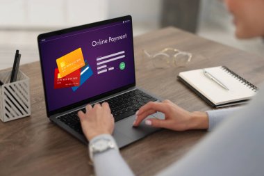 Masadaki dizüstü bilgisayarda ödeme uygulaması kullanan kadın, yakın plan.