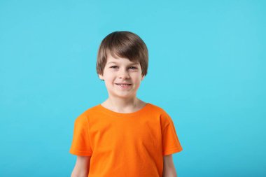 Açık mavi arka planda küçük şirin bir çocuğun portresi