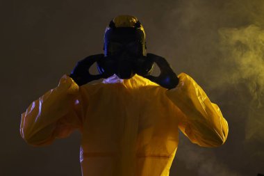 Karanlık arka planda gaz maskesi takan işçiler