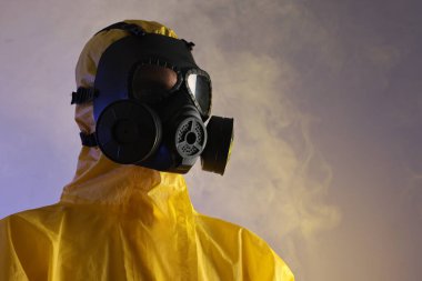 Mor arka planda duman içinde gaz maskesi takan işçiler, düşük açılı görüntüler. Metin için boşluk