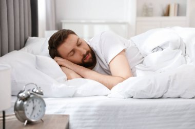 Yakışıklı genç adam, sabahları yatakta uyuyor.