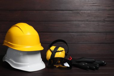 Sert şapkalar, kulaklıklar, eldivenler ve tahta yüzeyde koruyucu gözlükler. Metin için boşluk