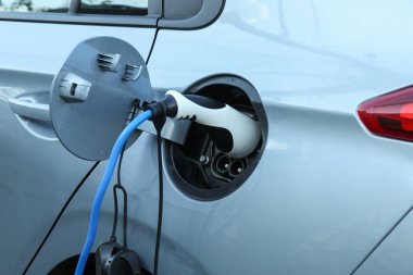 Dışarıdaki istasyondan modern elektrikli araba şarj ediliyor.