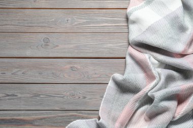 Ahşap masada yumuşak kareli eşarp, üst manzara. Metin için boşluk