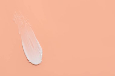 Mercan arka planda yüz kremi örneği, üst manzara. Metin için boşluk