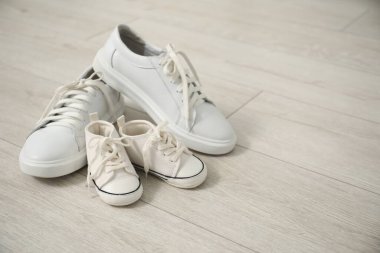 Yerde büyük ve küçük spor ayakkabılar, metin için yer