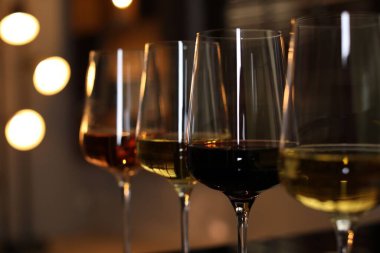 Bulanık ışıklara karşı bardaktaki farklı lezzetli şaraplar.