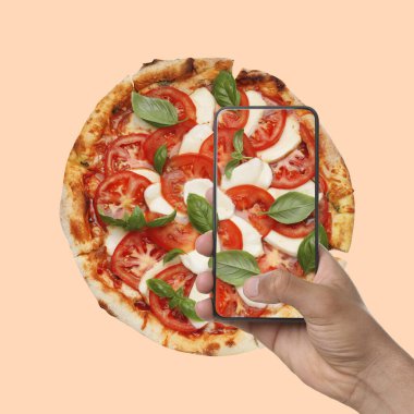 Adam bej arka planda pizza fotoğrafı çekiyor.