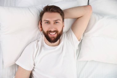 Yatakta yakışıklı genç bir adam, manzarası çok güzel.