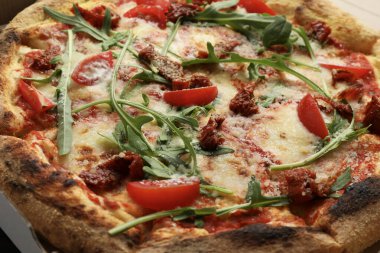 Peynirli, domatesli ve roka soslu lezzetli pizza.