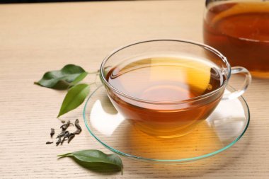 Yeşil çayı fincanda tazeleyen ve ahşap masada yapraklar, yakın plan