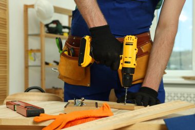 Zanaatkar atölyede matkapla çalışıyor, yakın plan.