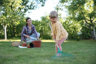 Mother and her daughter working together in garden